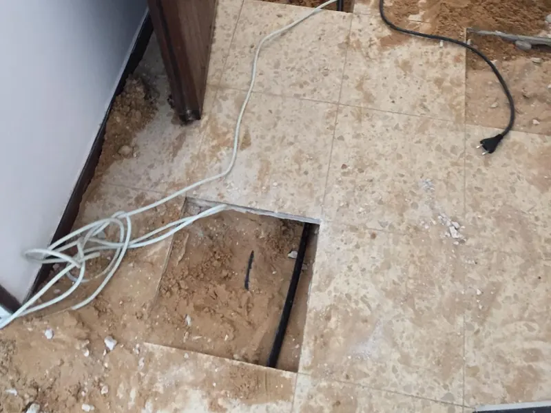 ריצוף פתוח בכמה נקודות לאורך מסדרון כדי להגיע לצנרת מתחת לרצפה